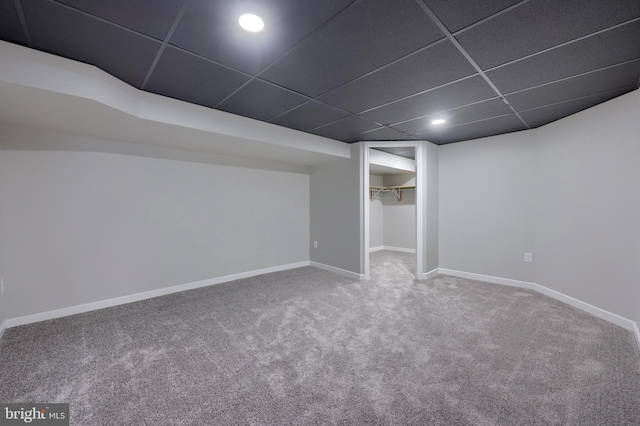 basement with a drop ceiling and carpet