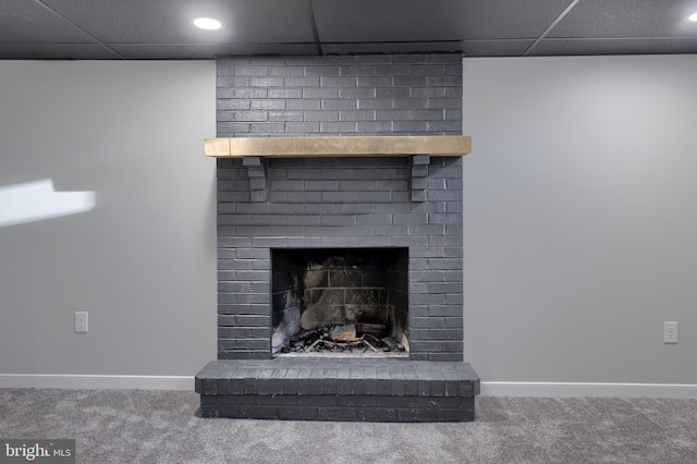 details featuring a paneled ceiling, carpet floors, and a brick fireplace