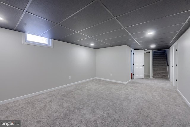 basement featuring carpet and a drop ceiling