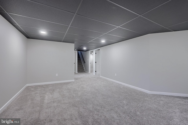 basement with carpet floors and a drop ceiling