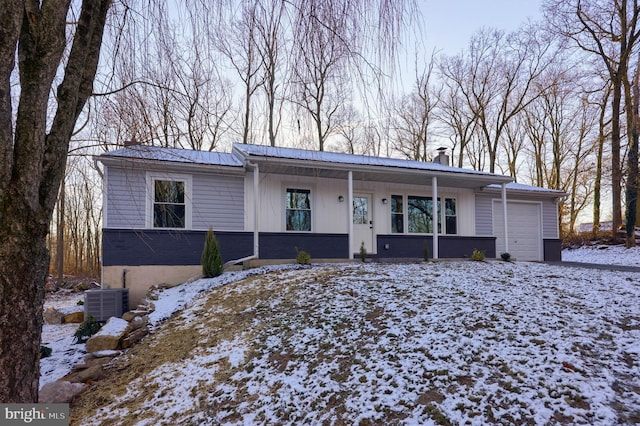 ranch-style home featuring a garage and cooling unit