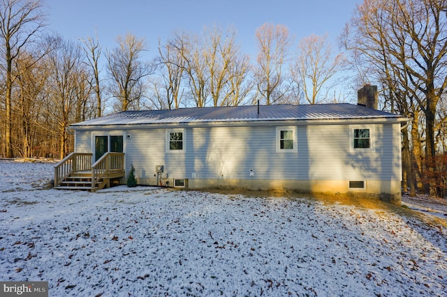 view of snow covered back of property