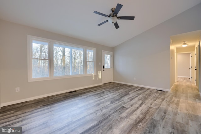 interior space with a wealth of natural light, ceiling fan, vaulted ceiling, and light wood-type flooring