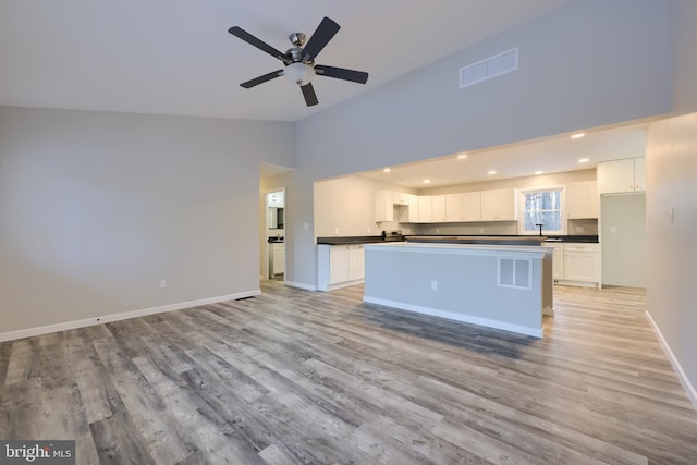 kitchen with light hardwood / wood-style flooring, white cabinetry, ceiling fan, and a kitchen island