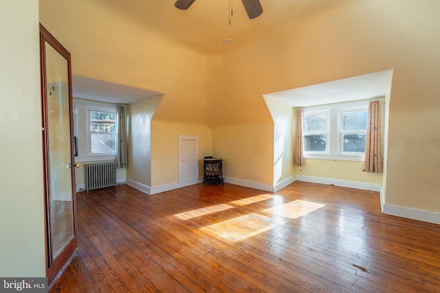 additional living space with hardwood / wood-style flooring, radiator, and ceiling fan