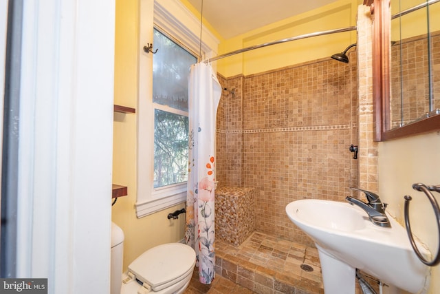 bathroom featuring tile walls, sink, a shower with curtain, and toilet