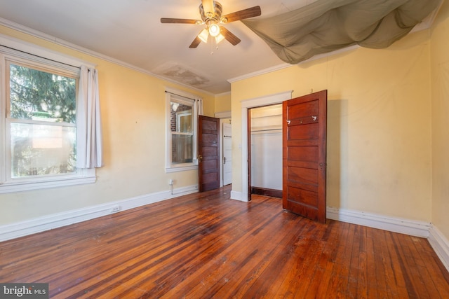 unfurnished bedroom featuring ceiling fan, ornamental molding, dark hardwood / wood-style floors, and a closet