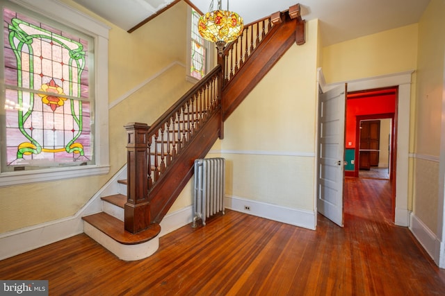 stairs featuring hardwood / wood-style flooring and radiator