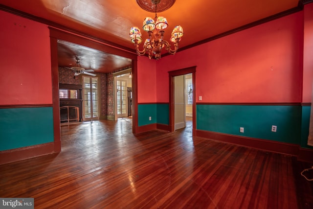 spare room with ceiling fan with notable chandelier, wood-type flooring, ornamental molding, and baseboard heating