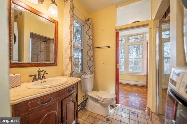 bathroom with vanity, a baseboard heating unit, tile patterned floors, and toilet