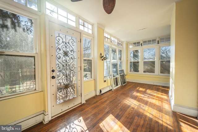 unfurnished sunroom with ceiling fan and a baseboard radiator