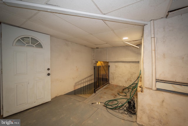 basement featuring baseboard heating and a paneled ceiling