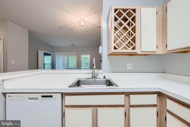 kitchen featuring white dishwasher, white cabinets, and sink