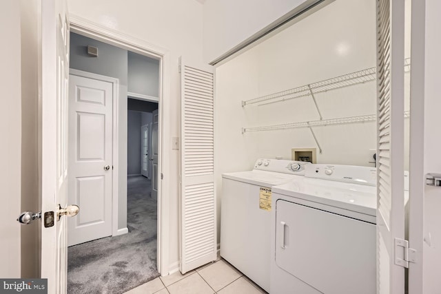 clothes washing area with light colored carpet and independent washer and dryer