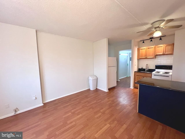 kitchen featuring decorative backsplash, a textured ceiling, white appliances, ceiling fan, and dark hardwood / wood-style floors