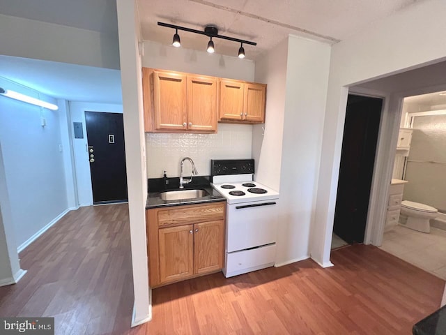 kitchen featuring backsplash, sink, rail lighting, light wood-type flooring, and white range with electric stovetop