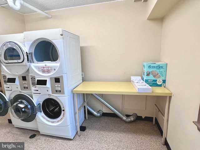 laundry room featuring a textured ceiling and stacked washer and clothes dryer