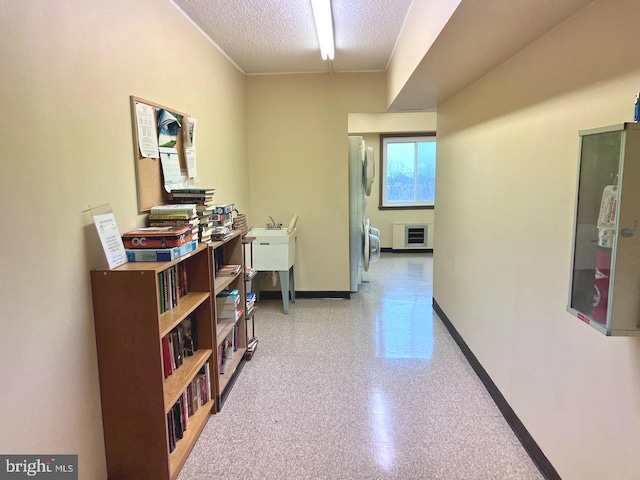 hall with a textured ceiling and heating unit