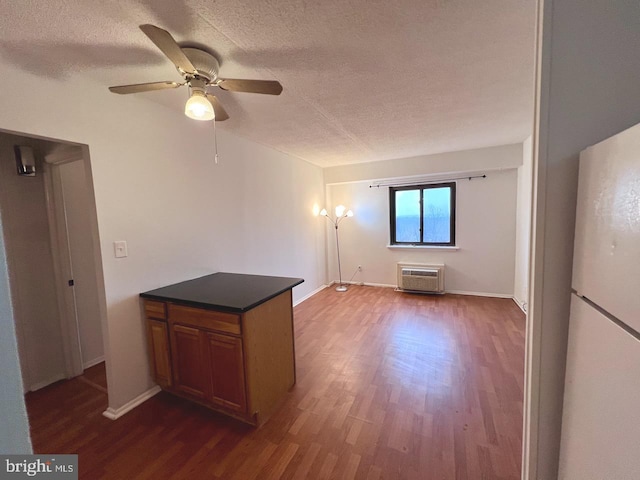 unfurnished living room with a textured ceiling, dark hardwood / wood-style flooring, and ceiling fan