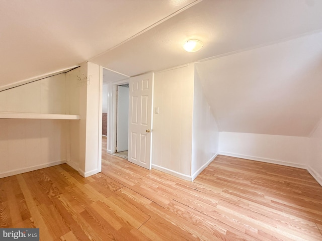 bonus room with lofted ceiling and light wood-type flooring