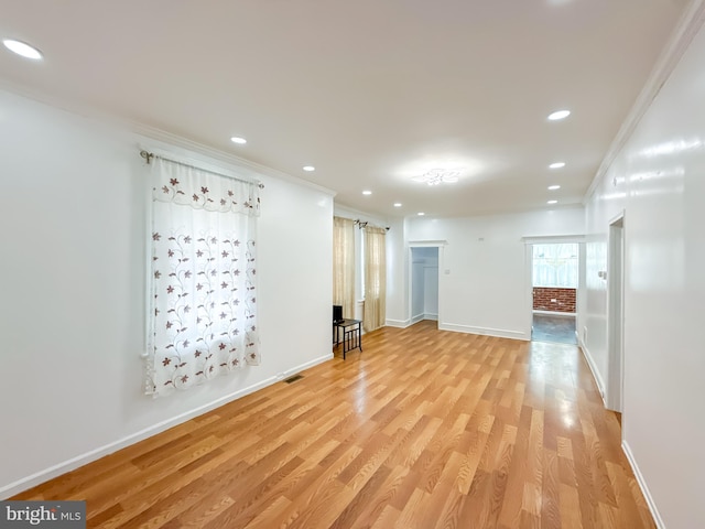 unfurnished room featuring light wood-type flooring and crown molding