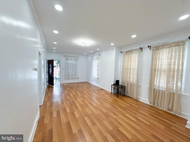 unfurnished living room featuring light hardwood / wood-style floors and ornamental molding