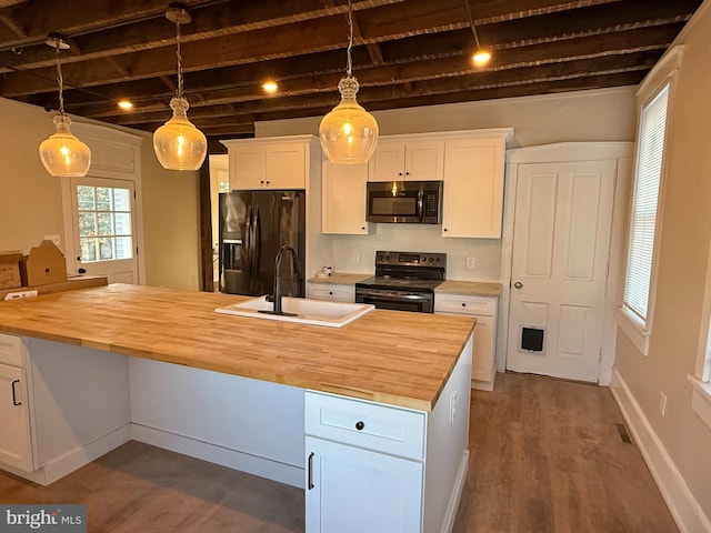 kitchen featuring electric stove, an island with sink, white cabinetry, black fridge with ice dispenser, and butcher block counters