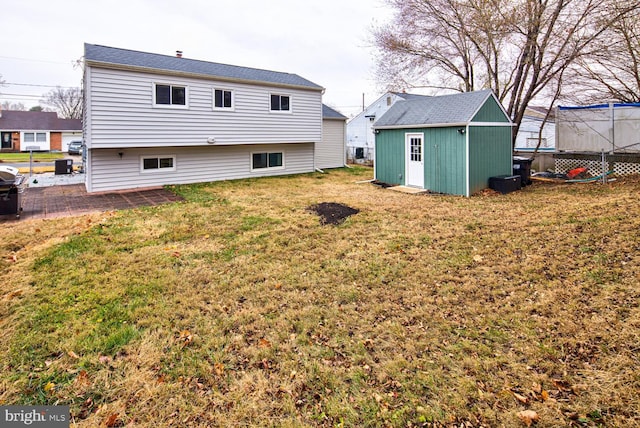 back of house featuring a yard and a shed