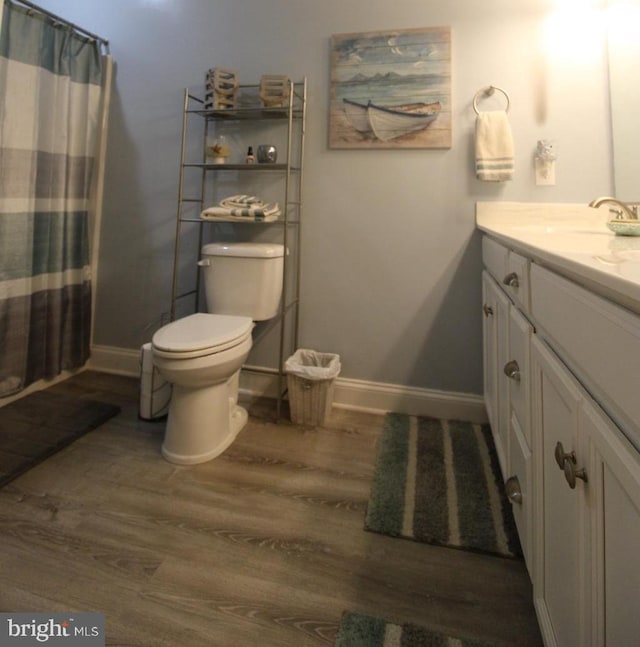 bathroom featuring vanity, hardwood / wood-style floors, a shower with curtain, and toilet