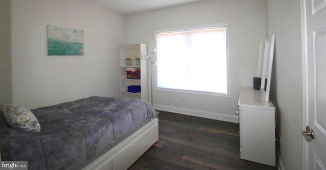 bedroom with dark hardwood / wood-style floors