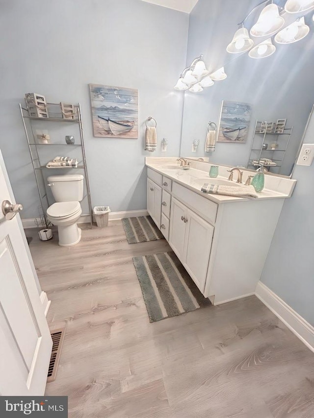 bathroom with vanity, hardwood / wood-style floors, and toilet