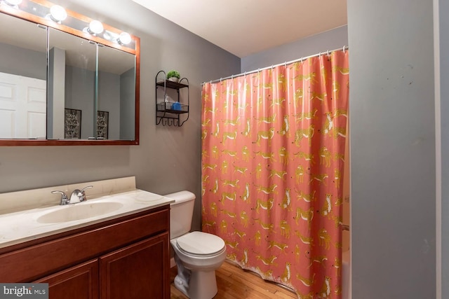 bathroom featuring a shower with curtain, vanity, hardwood / wood-style flooring, and toilet