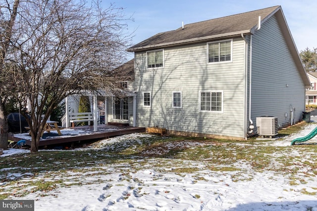 snow covered rear of property featuring central air condition unit and a wooden deck