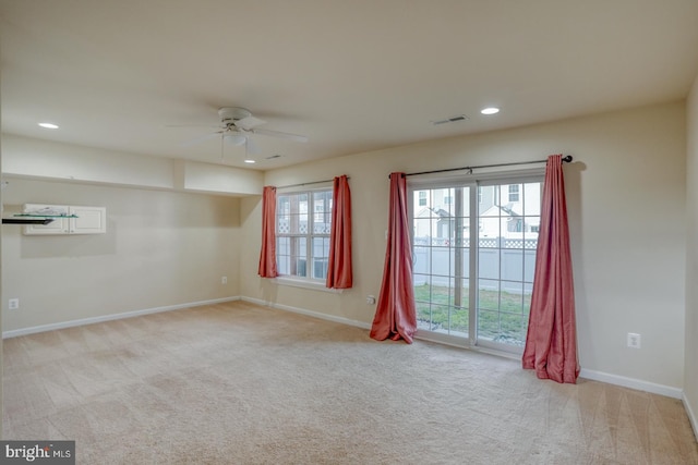 spare room with ceiling fan and light carpet