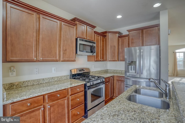 kitchen featuring light stone countertops, sink, and appliances with stainless steel finishes