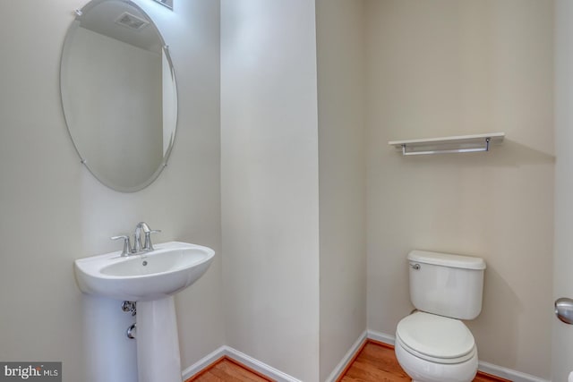 bathroom featuring hardwood / wood-style flooring and toilet