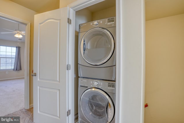 clothes washing area with carpet, ceiling fan, and stacked washer and clothes dryer