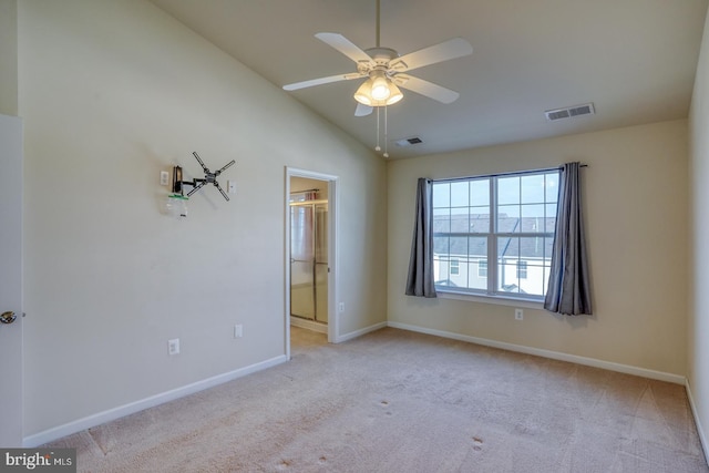 spare room featuring ceiling fan, light colored carpet, and lofted ceiling