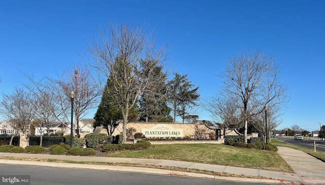 community / neighborhood sign featuring a yard