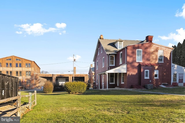 exterior space with central AC unit and a yard