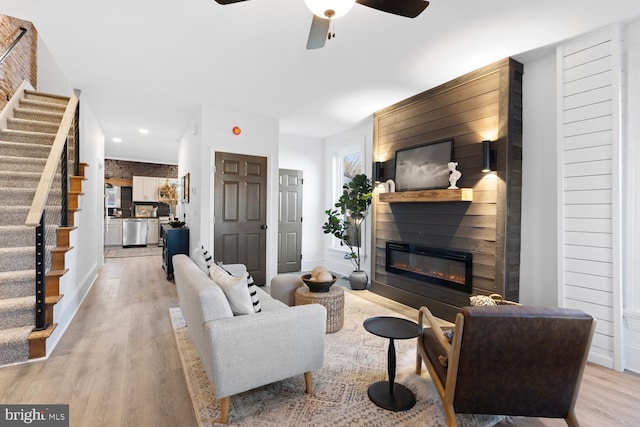 living room featuring ceiling fan and light hardwood / wood-style flooring