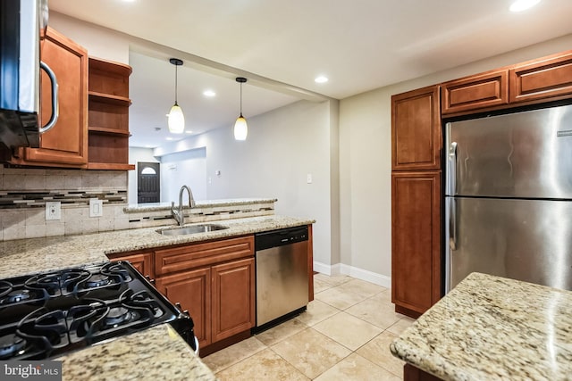 kitchen featuring light stone counters, stainless steel appliances, tasteful backsplash, and sink