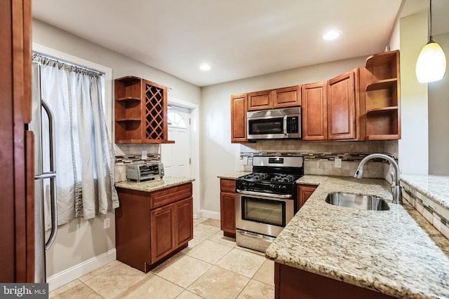 kitchen featuring sink, light tile patterned flooring, light stone countertops, pendant lighting, and appliances with stainless steel finishes