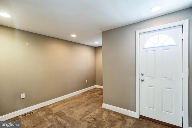 view of carpeted foyer entrance