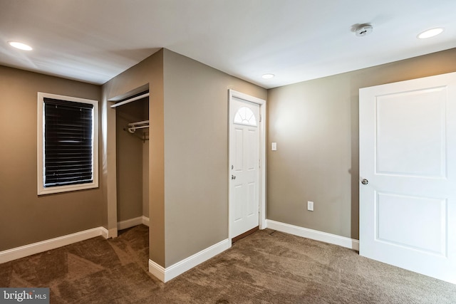 unfurnished bedroom with a closet and dark carpet