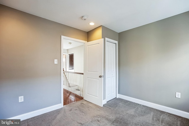 unfurnished bedroom with a closet and carpet flooring