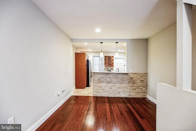 unfurnished living room with sink and light hardwood / wood-style flooring