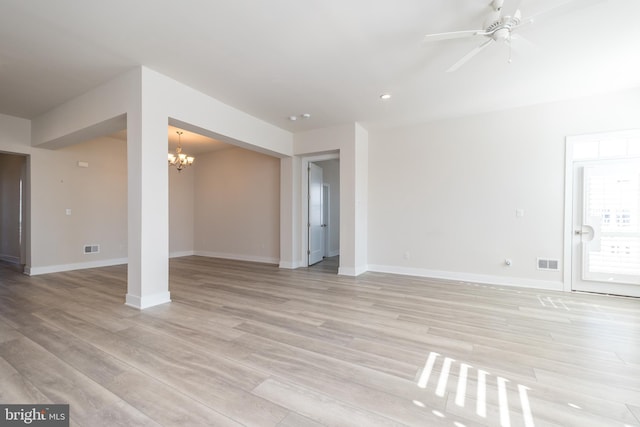 unfurnished living room featuring visible vents, baseboards, light wood-style floors, and ceiling fan with notable chandelier