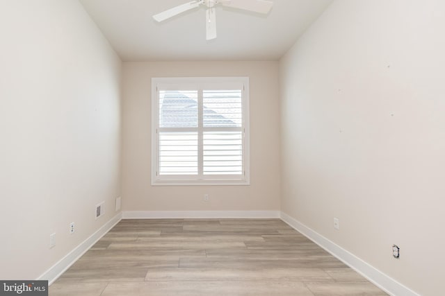 spare room featuring visible vents, light wood-style flooring, a ceiling fan, and baseboards