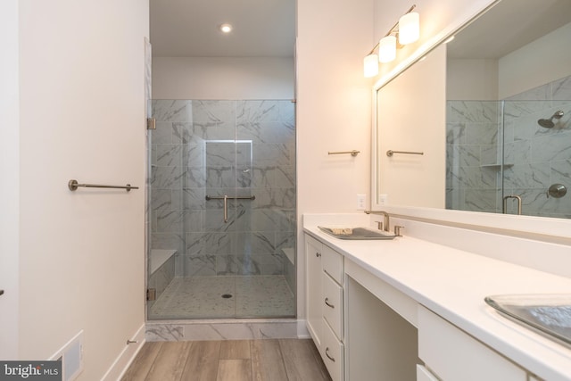 bathroom with double vanity, visible vents, a shower stall, and a sink